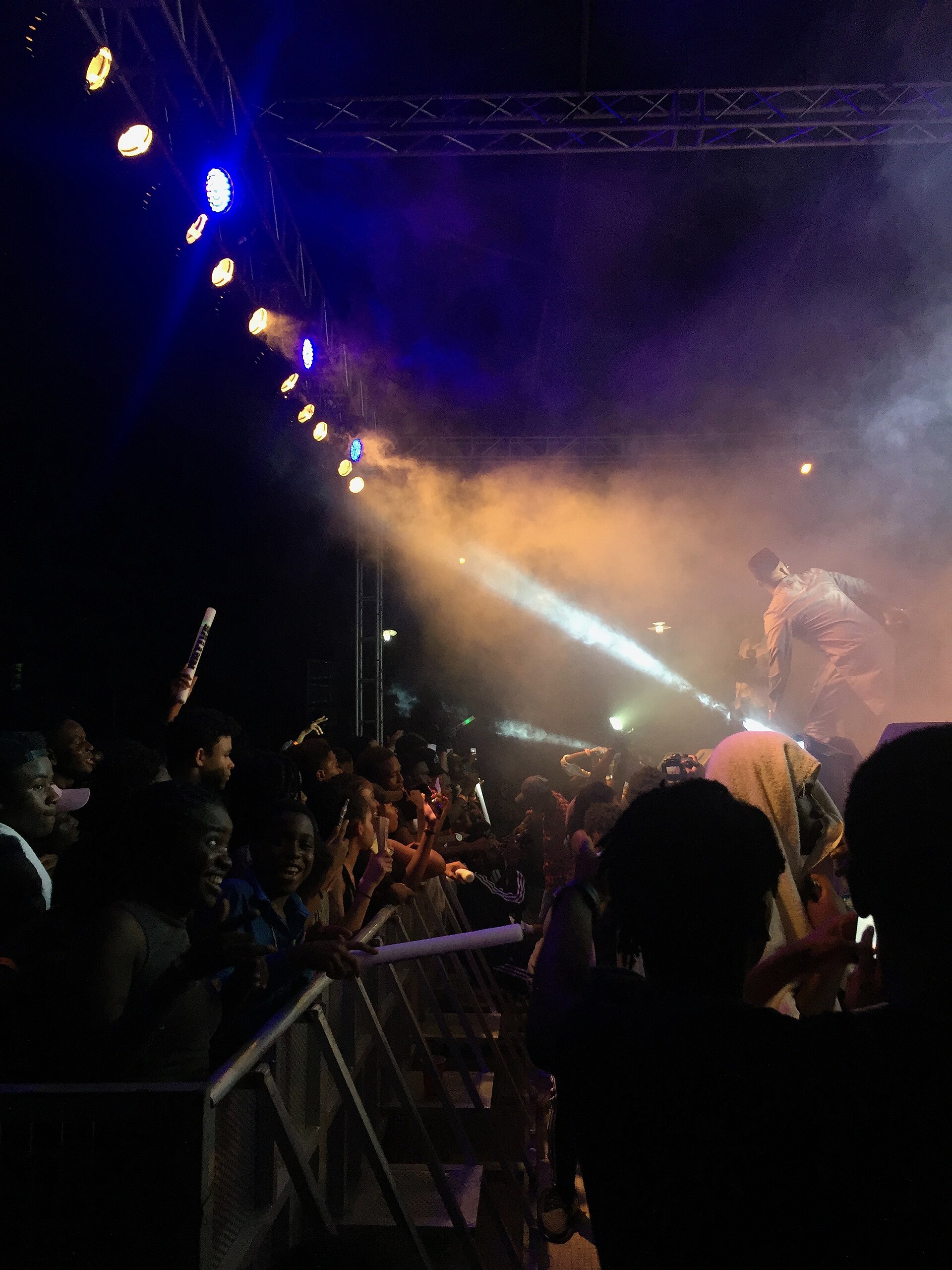 A cheering crowd pressed against the barrier under stage lights and haze at the Nativeland music festival in Lagos, Nigeria, December 2016