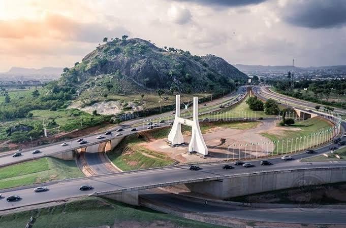 Abuja city gate beside a rocky hill and highway interchange in Nigeria